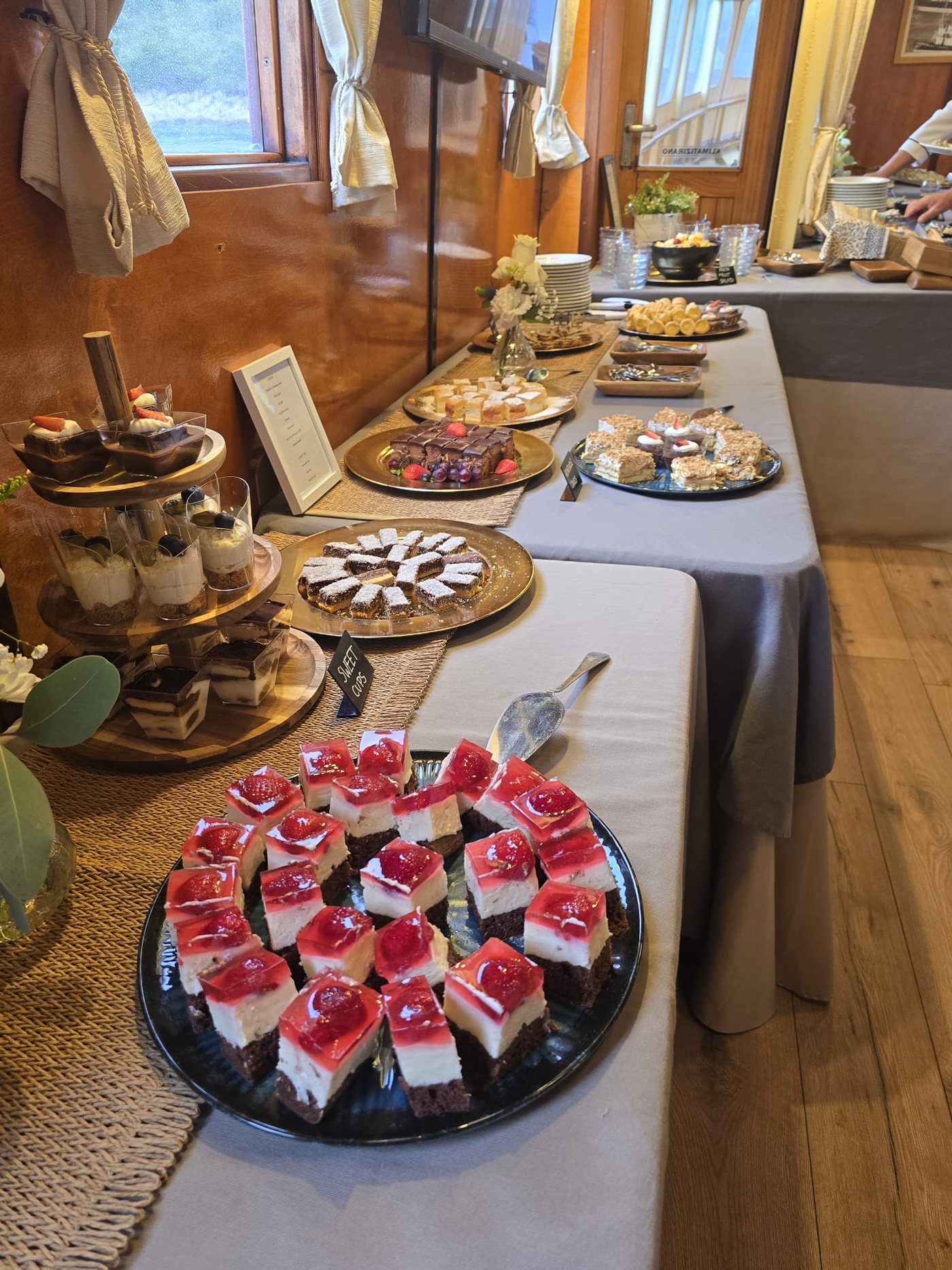 A dessert buffet of home-made cakes, cheesecake squares and sweet cups aboard Polaris