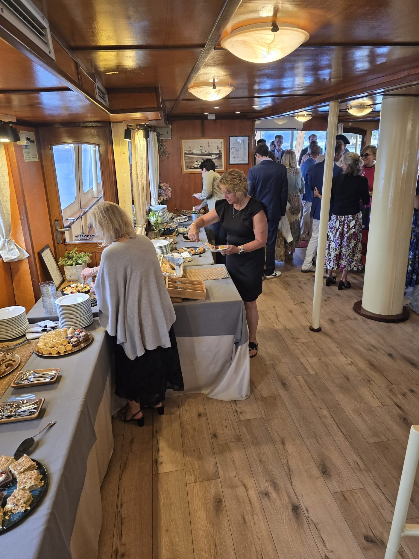 Guests serving themselves from a generous buffet spread in the wood-panelled cabin of Polaris