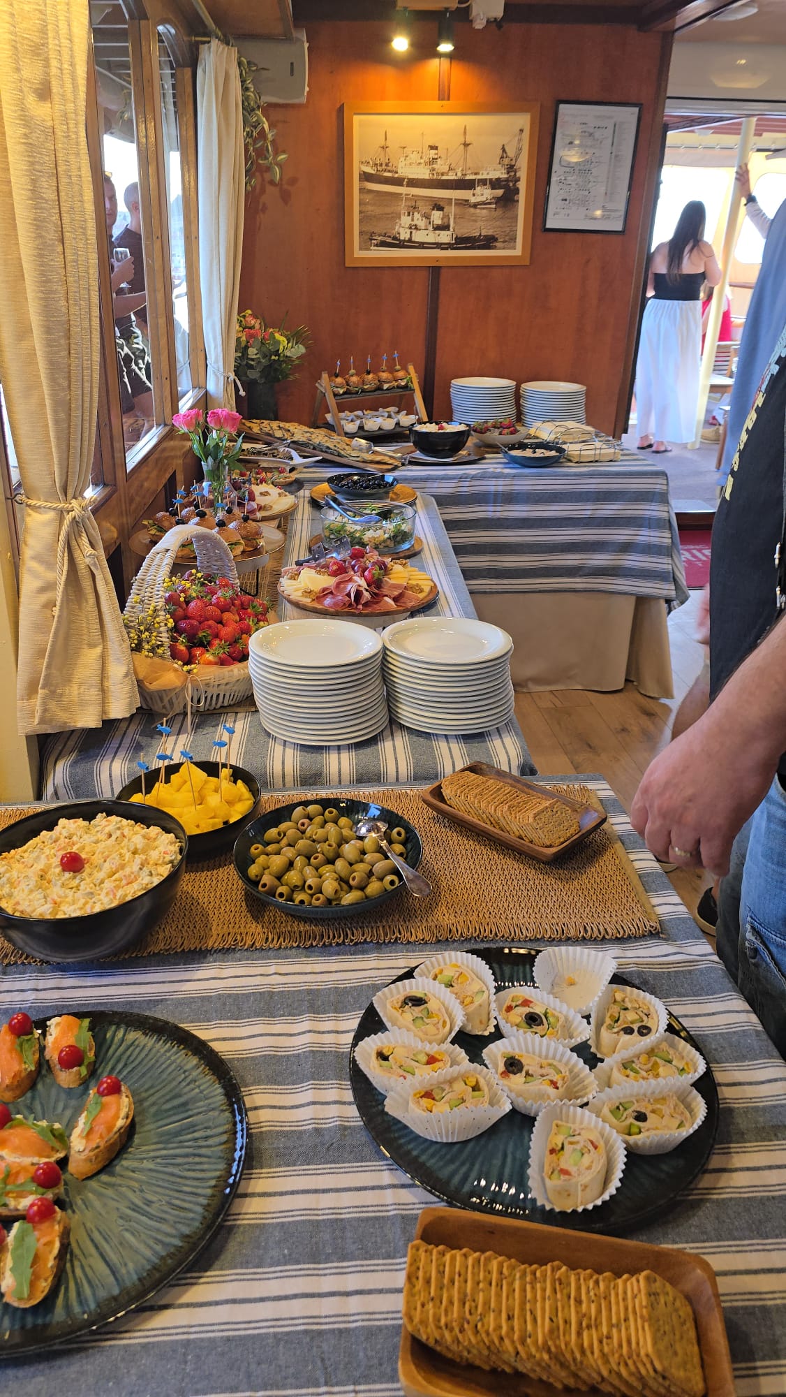 Buffet with salmon crostini, tortilla pinwheels, olives and a fresh strawberry basket