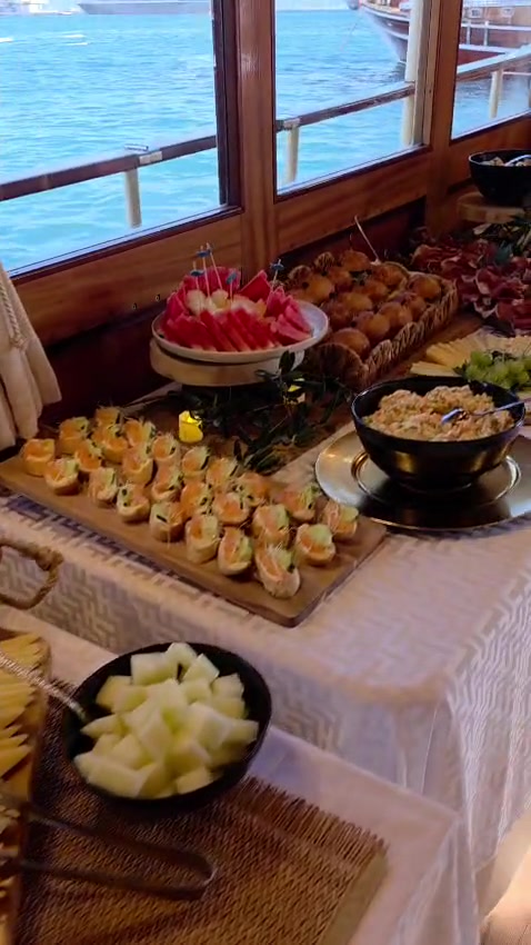 Lachs-Canapés, frische Wassermelone und warmes Gebäck am Fenster mit Meerblick