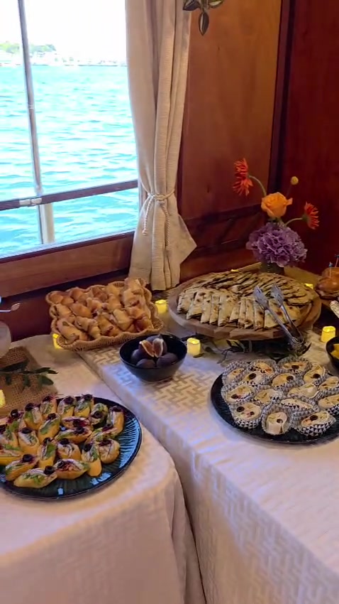 Buffettisch mit Soparnik, Canapés und Gebäck, mit frischen Blumen dekoriert, an Bord der Polaris