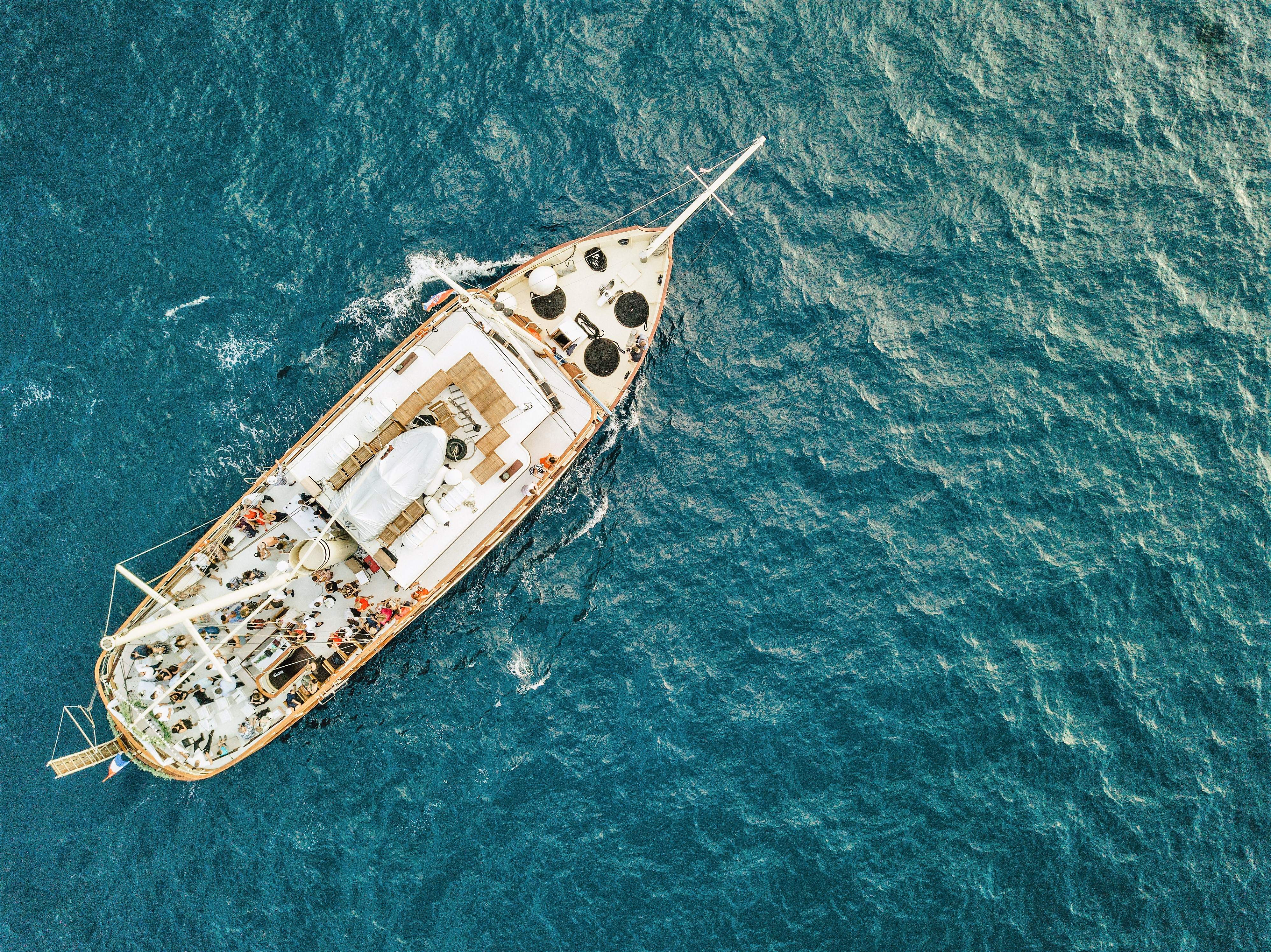 Drohnenaufnahme der Yacht Polaris auf der tiefblauen Adria mit Gästen auf dem offenen Deck