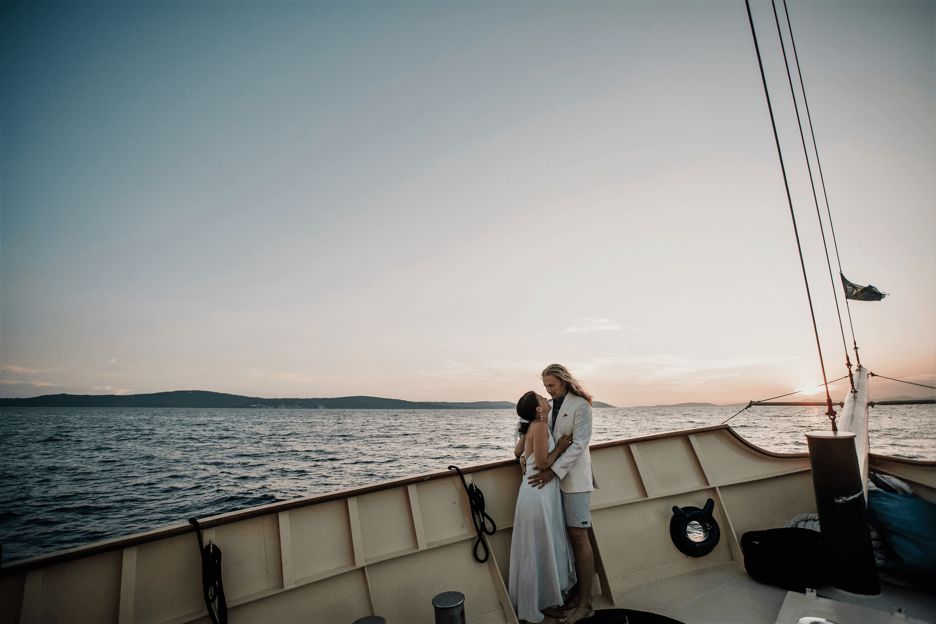 Newlyweds embracing on the deck of Polaris at sunset on the Adriatic