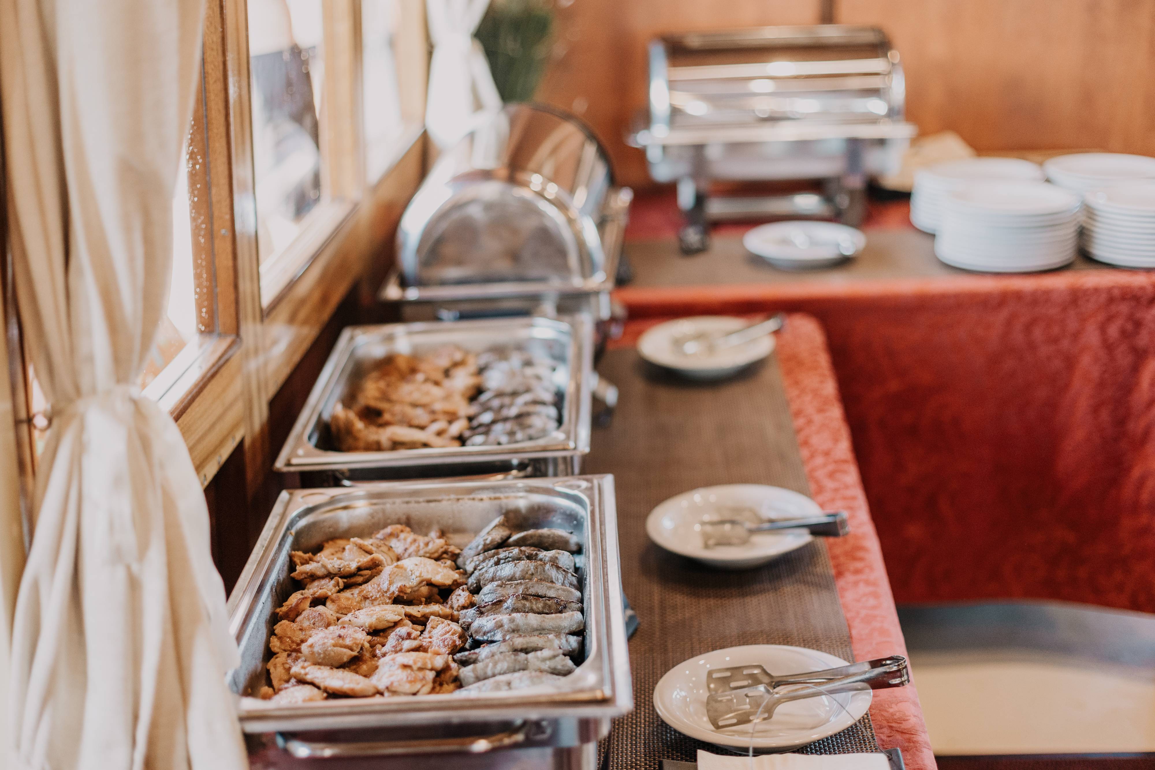 Grilled chicken and sausages served in chafing dishes by the salon window