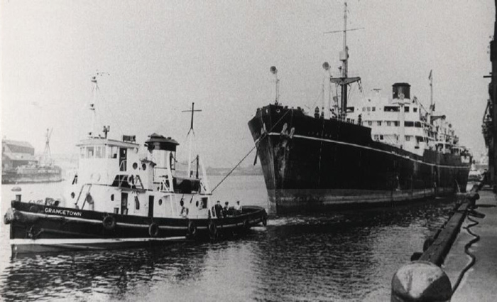 Der Schlepper Grangetown im Einsatz neben einem großen Hochseefrachter im Hafen