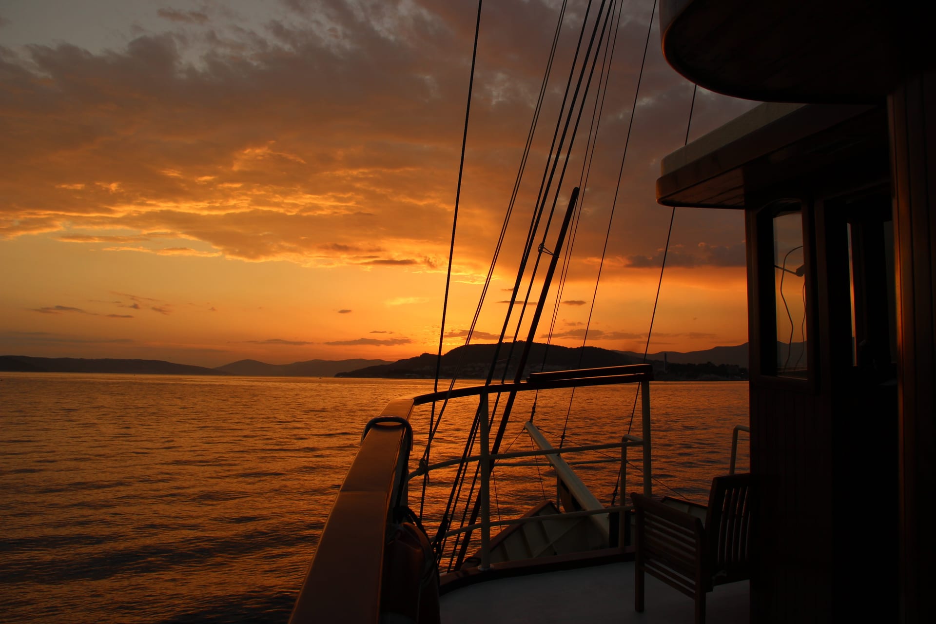 Deck und Takelage der Polaris als Silhouette vor einem dramatischen orangefarbenen Himmel