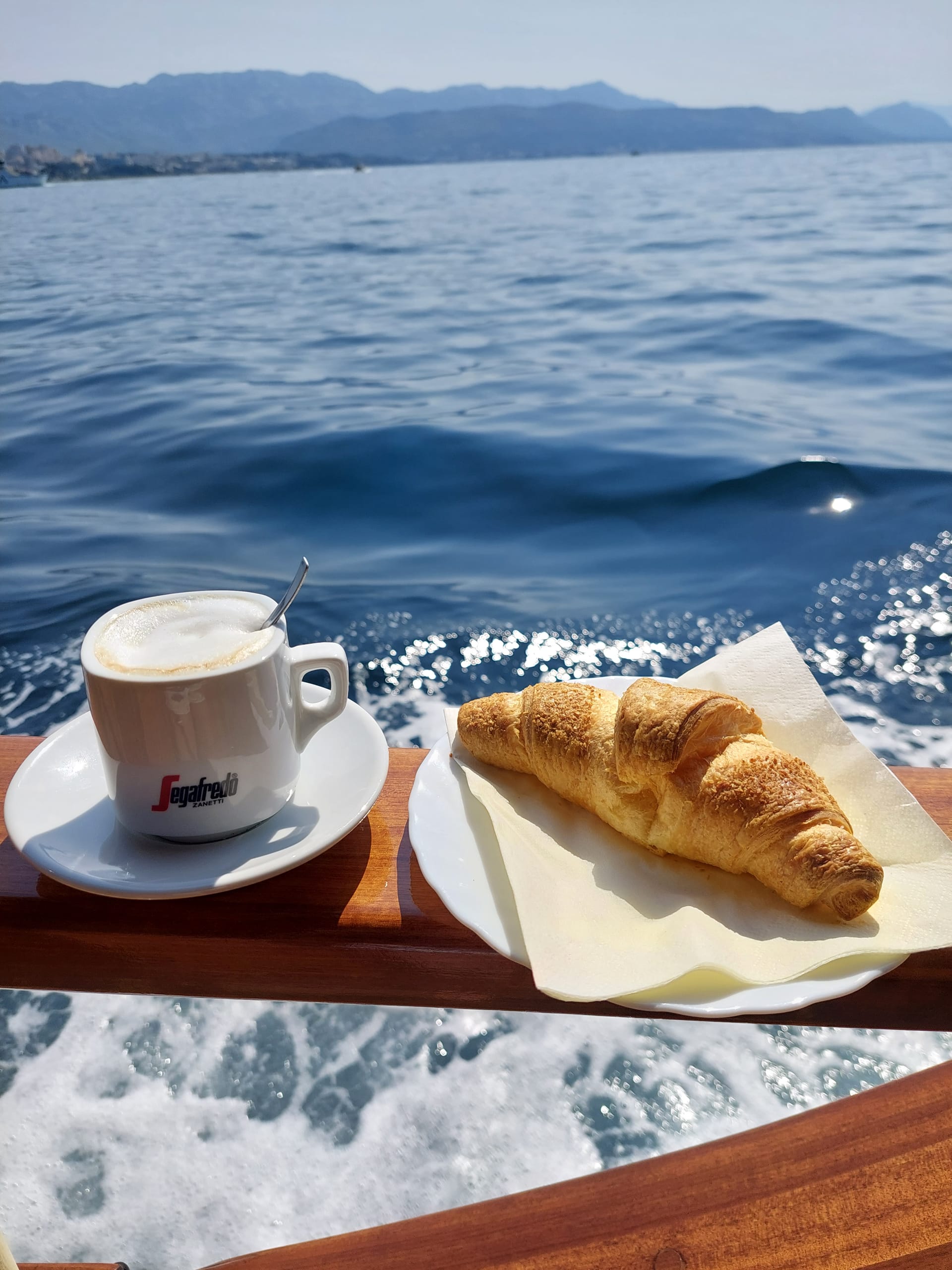 Begrüßungskaffee und Croissant auf der Reling